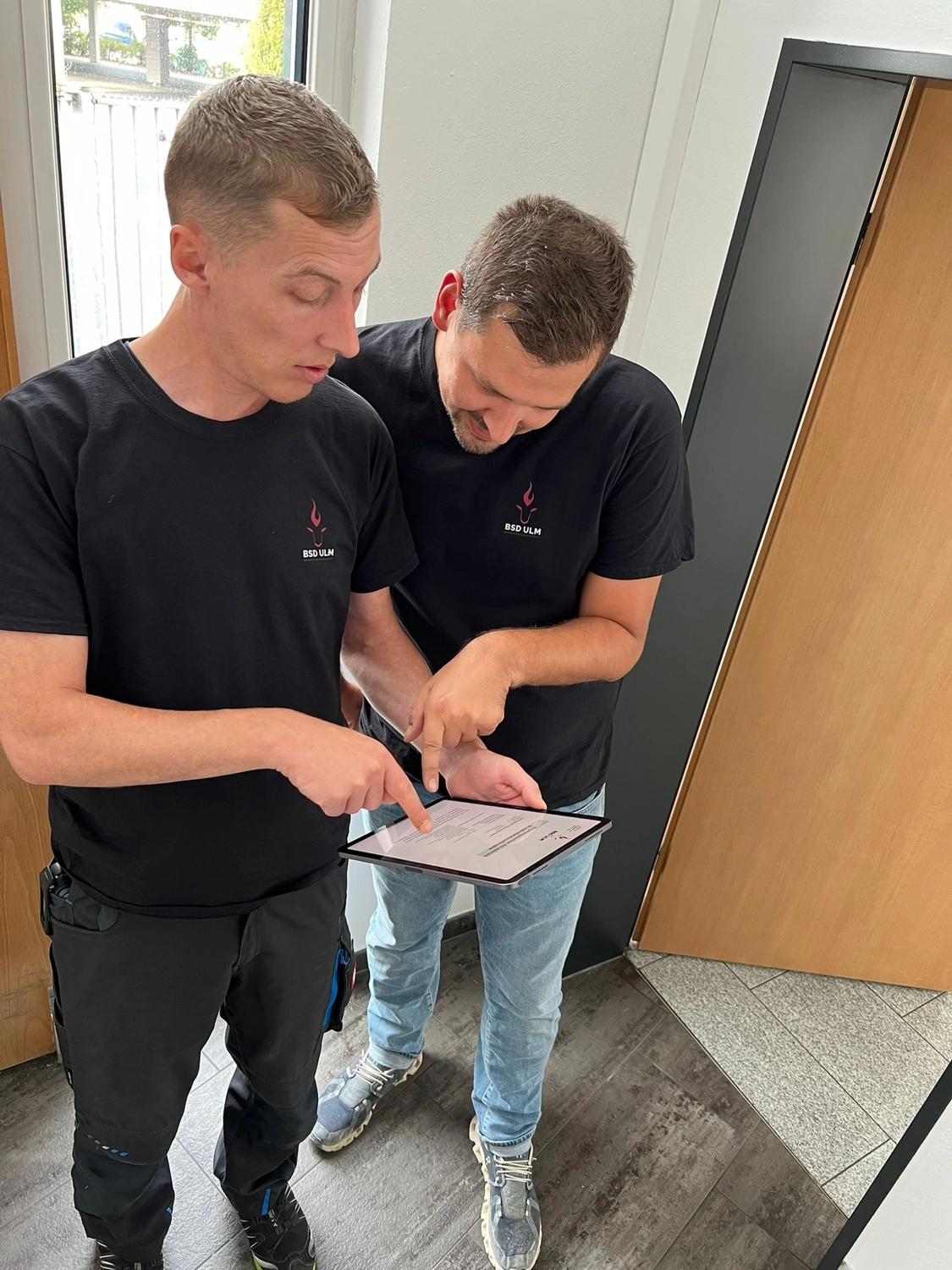 BSD Ulm Brandschutz Dienstleistungen - Zwei Mitarbeiter prüfen Checkliste auf Klemmbrett